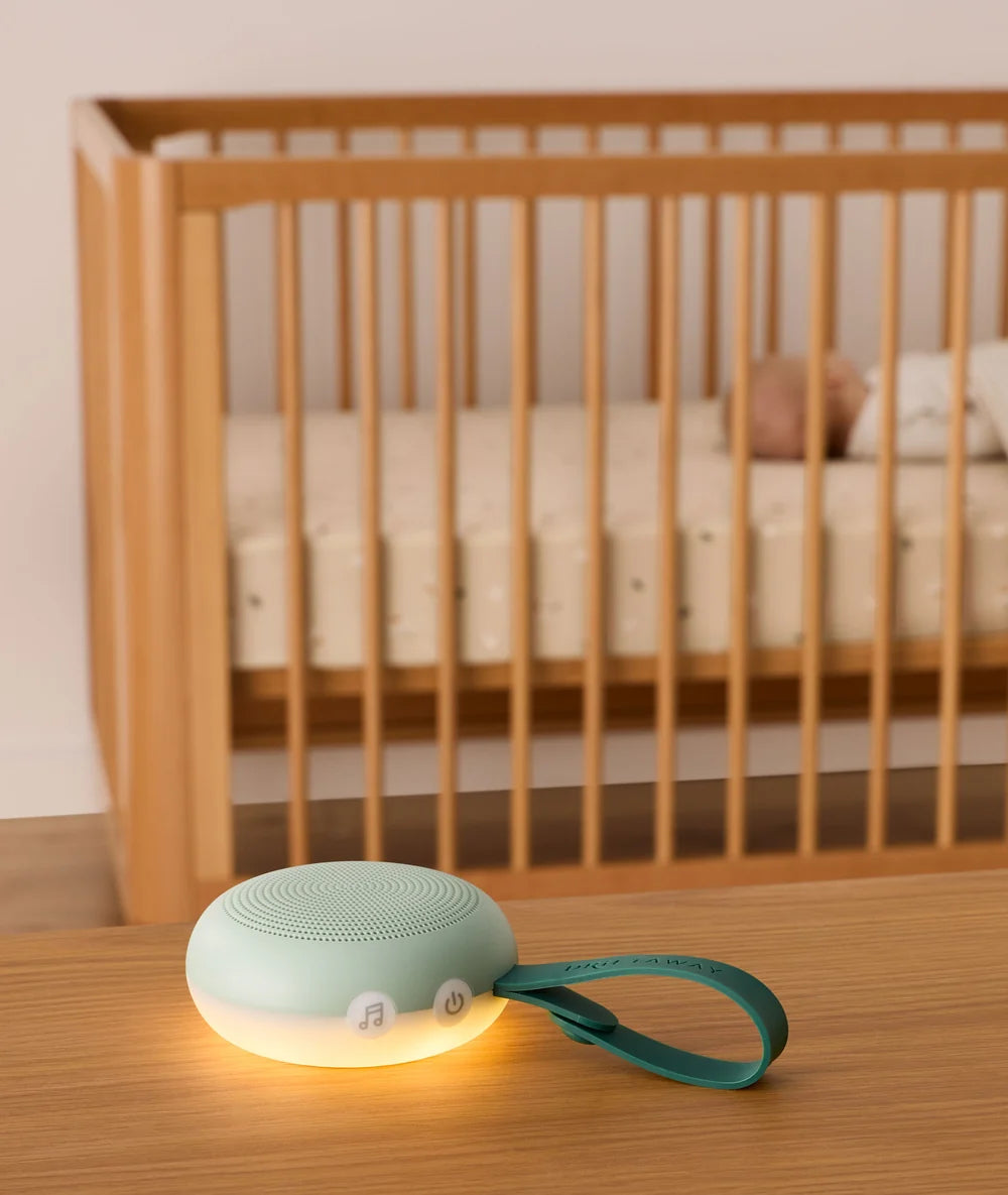 Sage Drift Away machine glowing beside a cot