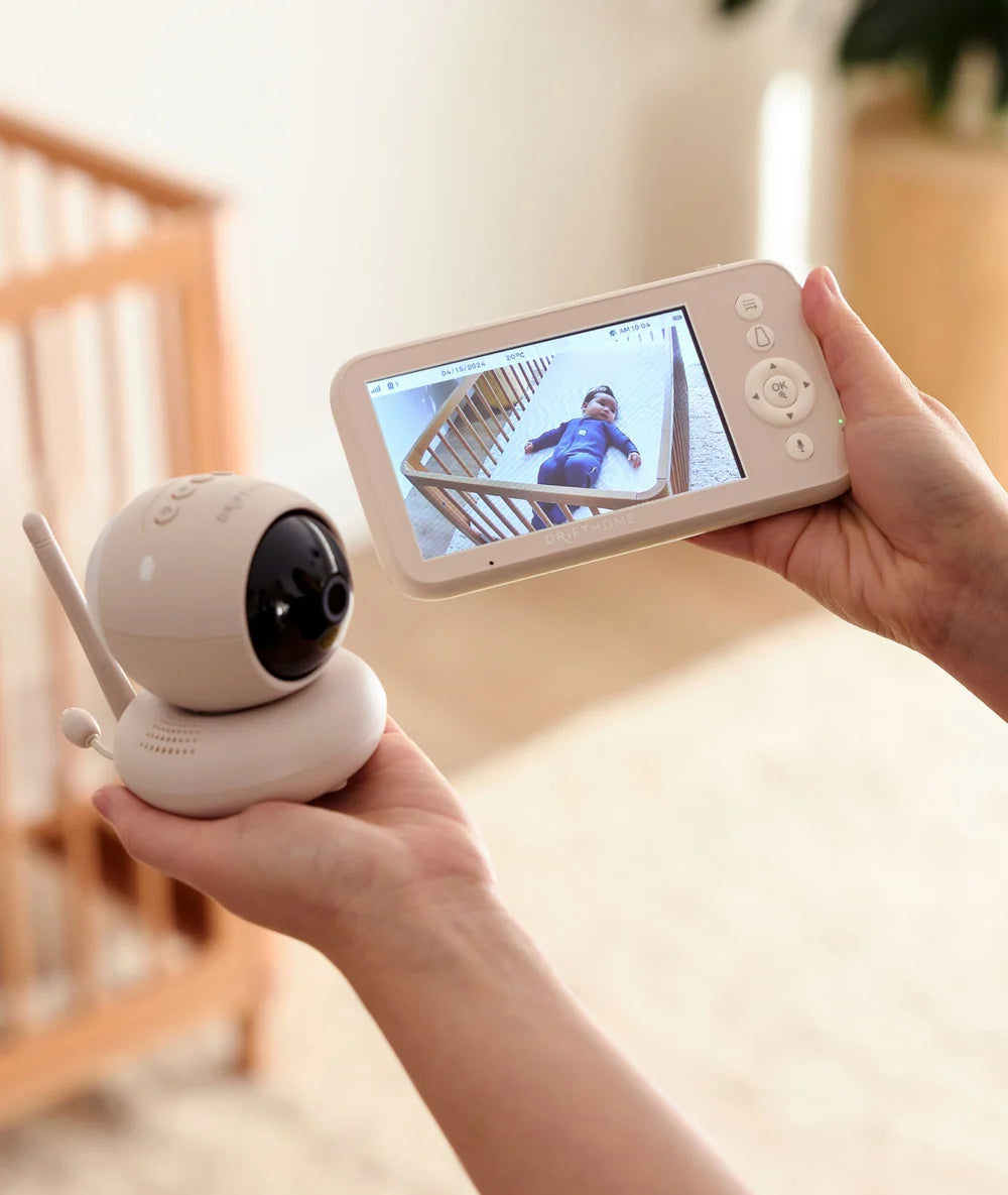 Parent holding Drift Home monitor and camera